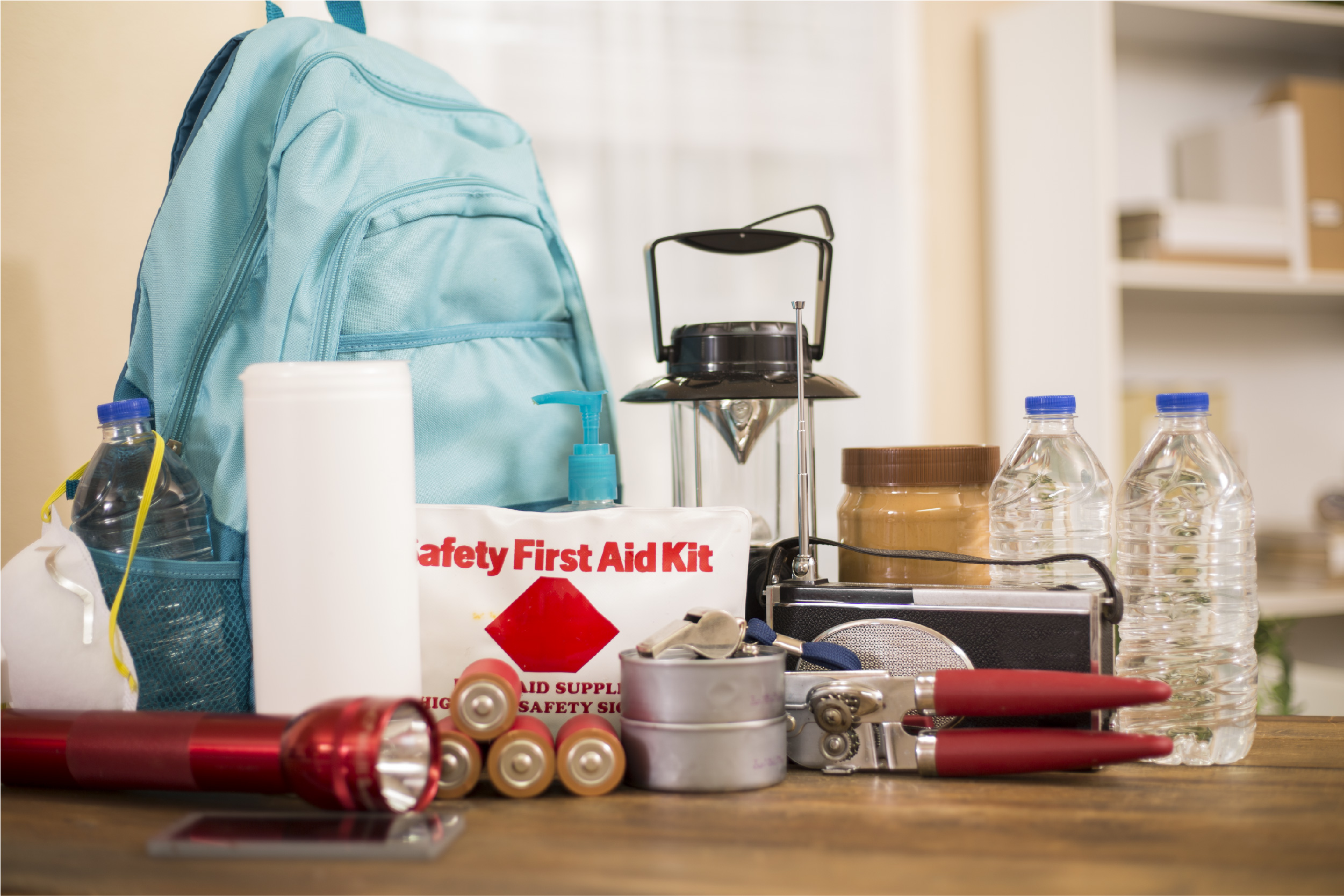 A disaster preparedness kit, including first aid kit, bottled water, a flashlight, and batteries,